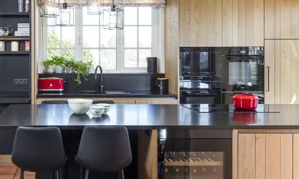 Landelijke keuken Keukens Schreurs met houten keukenfronten, een zwart werkblad en zwarte keukentoestellen