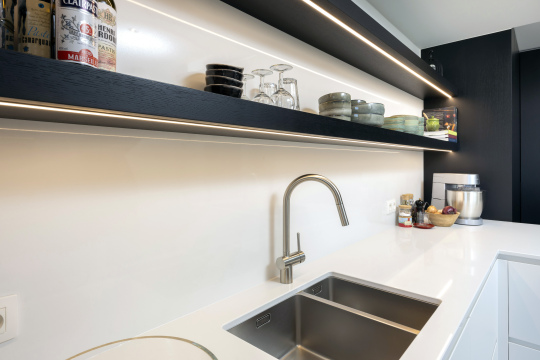 Moderne witte keuken, Keukens Schreurs, wit werkblad, zwarte leggers, verlichte leggers, dubbele spoelbak, chroom kraan