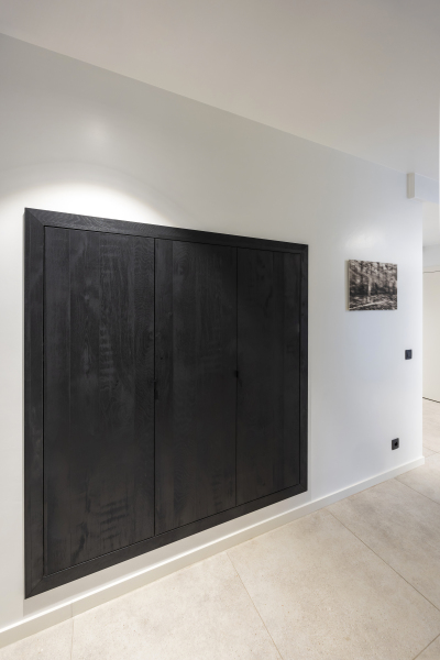 Maatwerk schoenenkast in zwarte houtkleur ingewerkt in nis met push-to-open deuren.