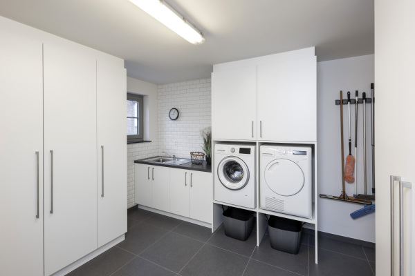 Functionele berging wasplaats met wasmachine en droogkast op ergonomische hoogte.