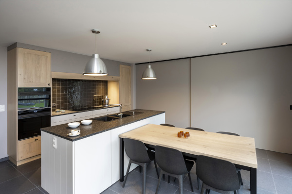 Op maat gemaakte schuifdeur om keuken en living van elkaar af te scheiden. Landelijke keuken graniet Steel Grey artiskin