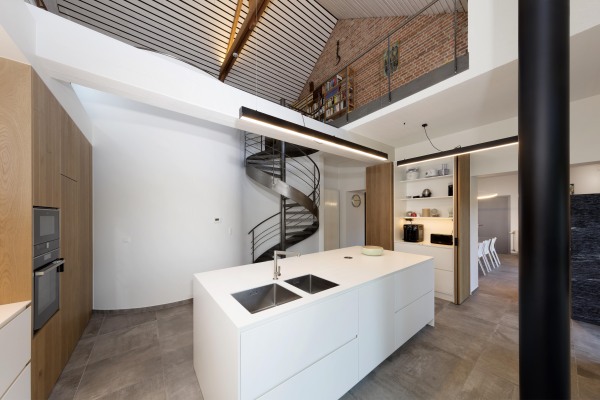 Moderne keuken in ruimte open tot in de nok wit keukeneiland metalen wenteltrap kolomkasten eik inschuifdeuren koffiecorner