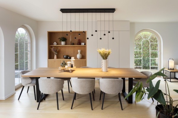 Eetkamer met maatwerk buffetkast in eikenhout, ruime eettafel en comfortabele stoelen in een moderne, lichte ruimte.
